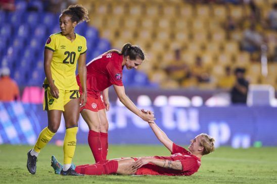 Canadá repite final en la CONCACAF W. Gilles ayuda a su compañera Schmidt a levantarse.