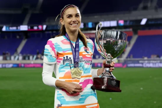 Morgan le da a San Diego la Challenge Cup. La jugadora posa sosteniendo la NWSL Challenge Cup y el trofeo MVP del torneo.