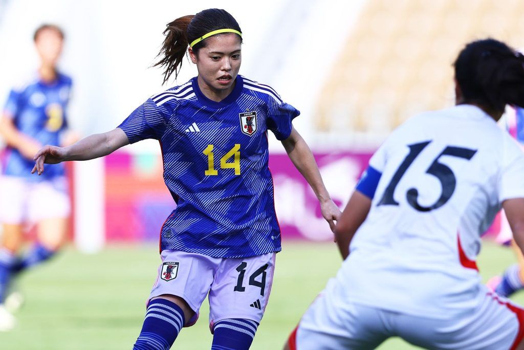 Yui Hasegawa y Wi Jong-Sim disputan un balón.
