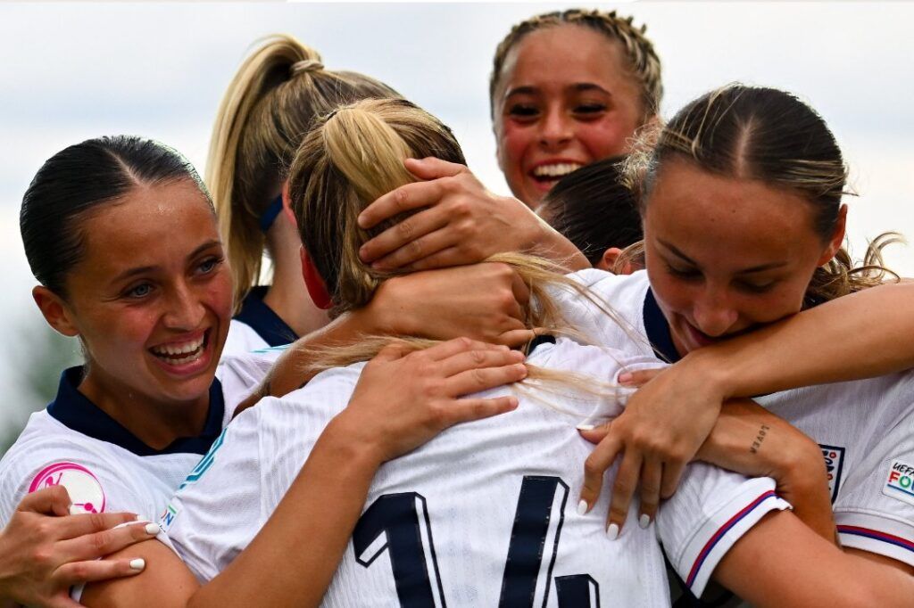 Inglaterra pasa como primera de grupo. Las jugadoras inglesas abrazan a Poppy Pritchard tras anotar el gol de la victoria.