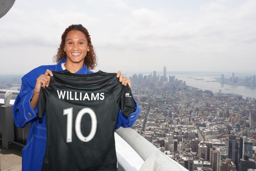Lynn Williams seguirá en Gotham. La jugadora posa con su camiseta desde lo alto del Empire State Building. Al fondo, una vista panorámica de la ciudad de Nueva York.