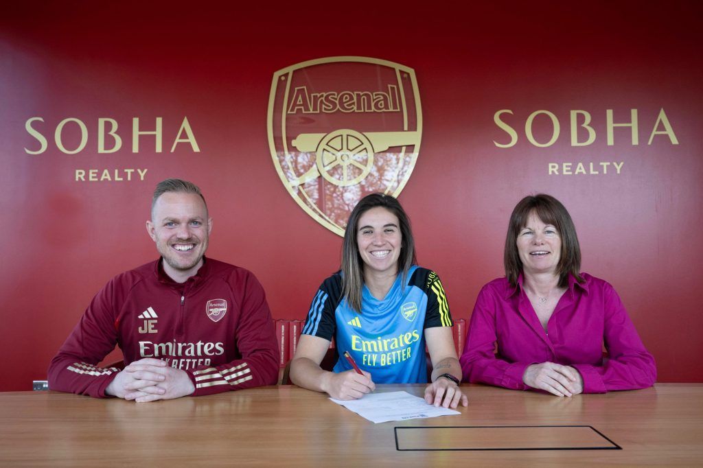Mariona Caldentey, a la conquista de la WSL. La jugadora posa sonriente firmando su nuevo contrato entre Jonas Eidevall, entrenador del Arsenal, y Clare Wheatley, directora deportiva del club.