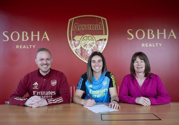 Mariona Caldentey, a la conquista de la WSL. La jugadora posa sonriente firmando su nuevo contrato entre Jonas Eidevall, entrenador del Arsenal, y Clare Wheatley, directora deportiva del club.