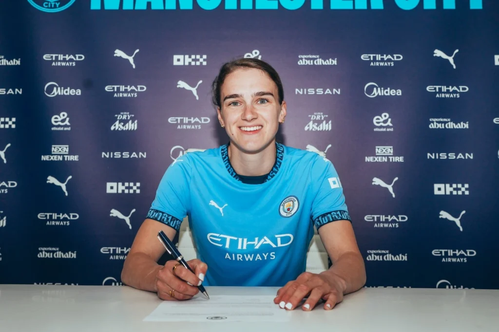 Miedema, el gran fichaje del City. La jugadora posa sonriente mientras firma su contrato con su nuevo equipo.