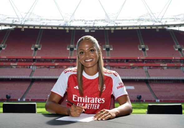 Taylor Hinds regresa al Arsenal. La jugadora posa firmando su primer contrato con la gradería del Emirates Stadium de fondo.