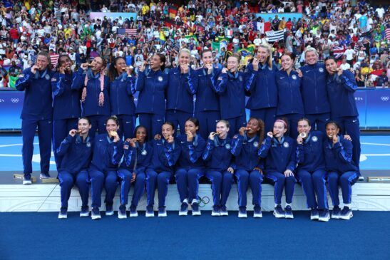 La historia se repite: Estados Unidos pentacampeona. Las jugadoras estadounidenses posan mordiendo sus medallas en lo más alto del podio.